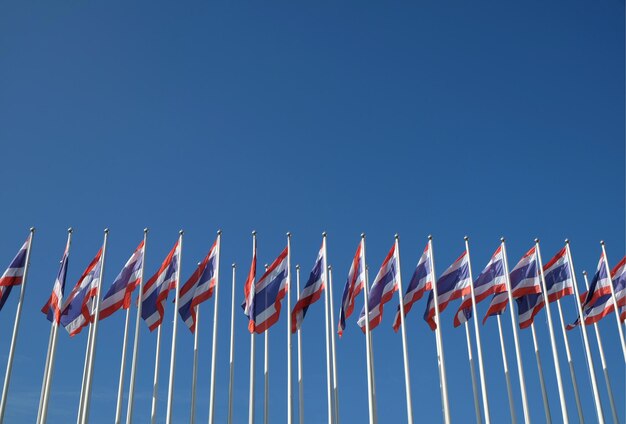 Foto lage hoek van vlaggen tegen een heldere blauwe hemel