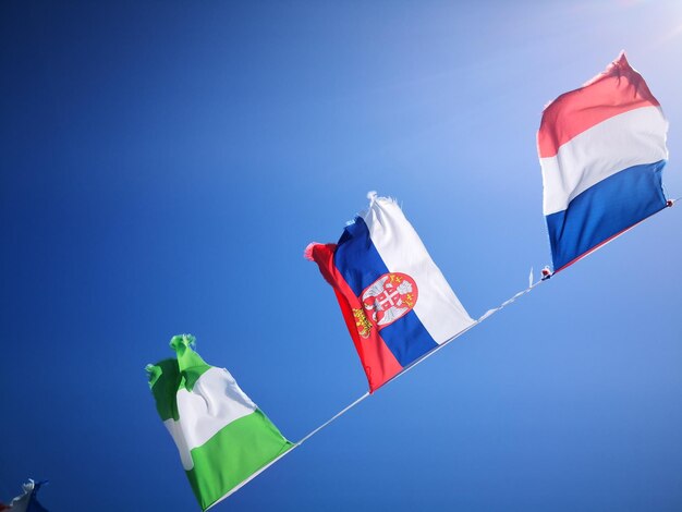 Foto lage hoek van vlaggen vlag tegen een heldere blauwe hemel