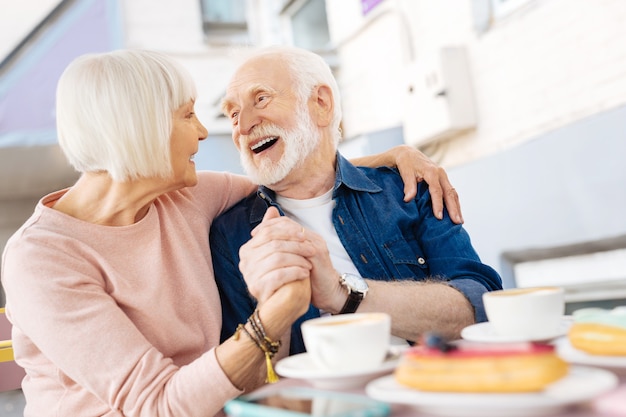 lage hoek van vrolijke senior paar hand in hand en lachen