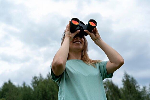 Foto lage hoek van vrouw met camera tegen de lucht