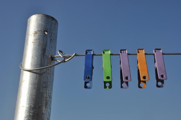 Foto lage hoek van waspinnen die aan een touw hangen tegen de blauwe hemel