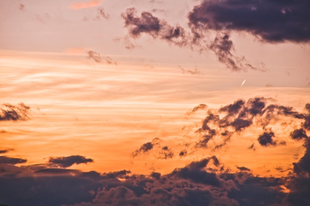 Lage hoek van wolken in oranje hemel tijdens zonsondergang