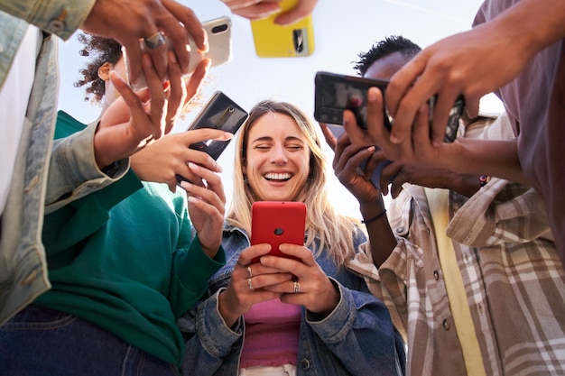 Foto lage hoekbeeld van een groep jonge tieners die mobiele telefoons gebruiken concept van technologische verbinding
