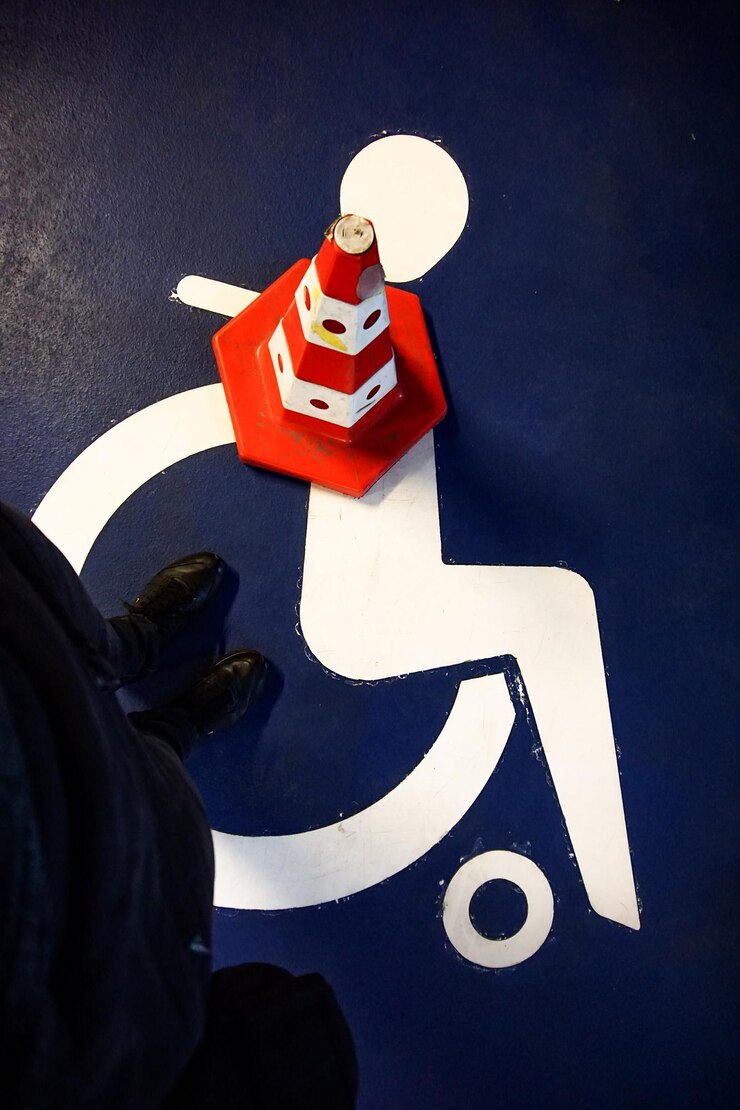 Foto lage hoekbeeld van een persoon die op een voetgangersbord staat door een verkeerskegel