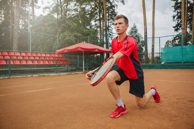 Lage hoekmening van bepaalde jonge man tennissen