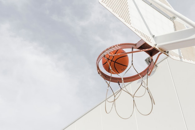 Foto lage hoekmening van een basketbal dat door hoepel valt