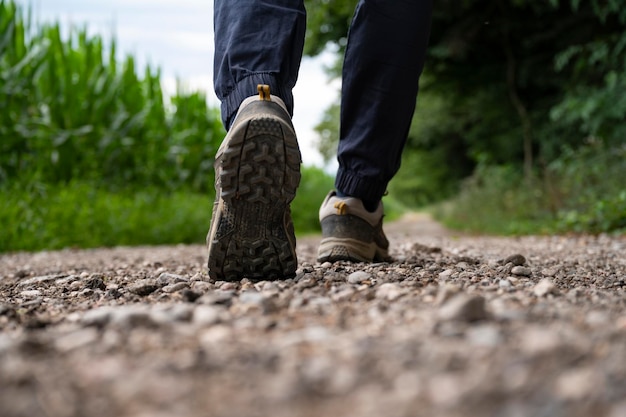 Lage hoekmening van een zool van een man in wandelschoenen die op een onverharde weg lopen