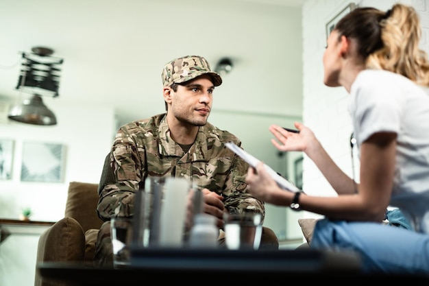 Lage hoekmening van jonge militaire officier die counseling heeft en praat met vrouwelijke arts