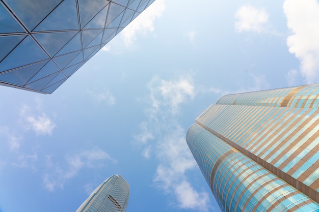 Lage mening van wolkenkrabbers met blauwe hemel en wolken en bureau die moderne zaken bouwen