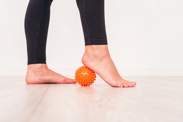 Lage sectie van meisje die met spanningsbal uitoefenen in het ziekenhuis. massage bal onder de voet.