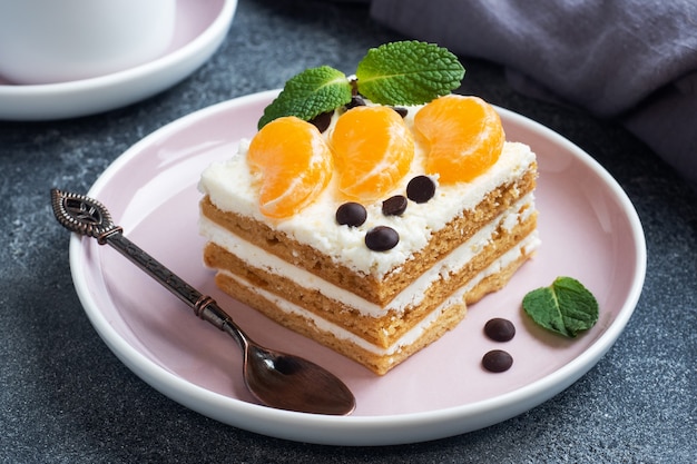 Lagen van biscuitgebak met botercrème, versierd met plakjes mandarijnchocolade en munt. Heerlijk zoet dessert voor op de thee.