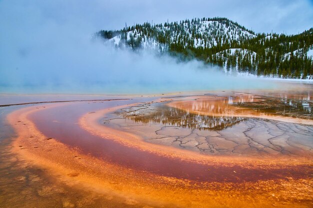 Lagen van rood en oranje water uit de lente in de winter van Yellowstone