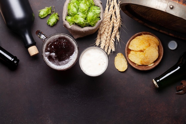 Photo lager beer mug bottles hops and wheat on old stone table