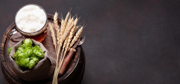 Foto lager boccale di birra luppolo e grano sul vecchio barilotto