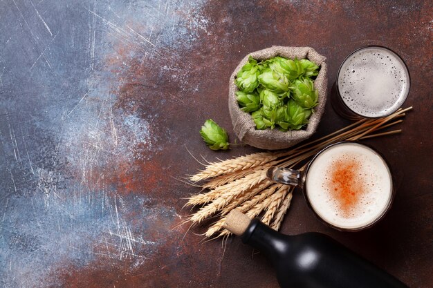 오래된 석조 테이블에 있는 라거 맥주 머그 홉과 밀