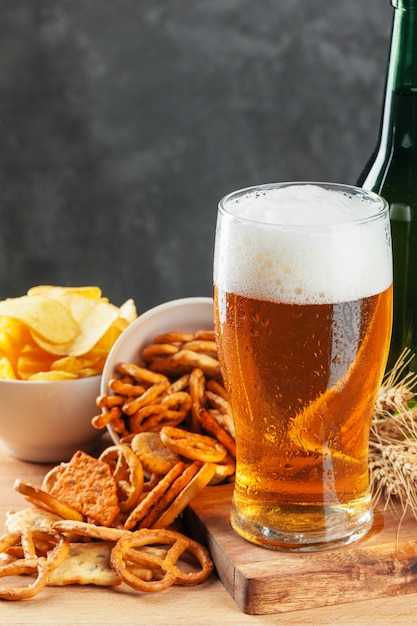 Lager beer and snacks on stone table. Cracker, chips side view