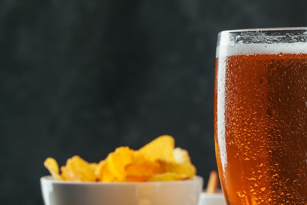 Lager beer and snacks on stone table.