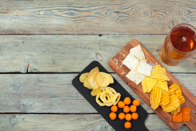 Photo lager beer and snacks on wooden surface table.