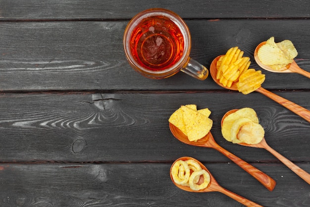 Lager beer and snacks on wooden table.