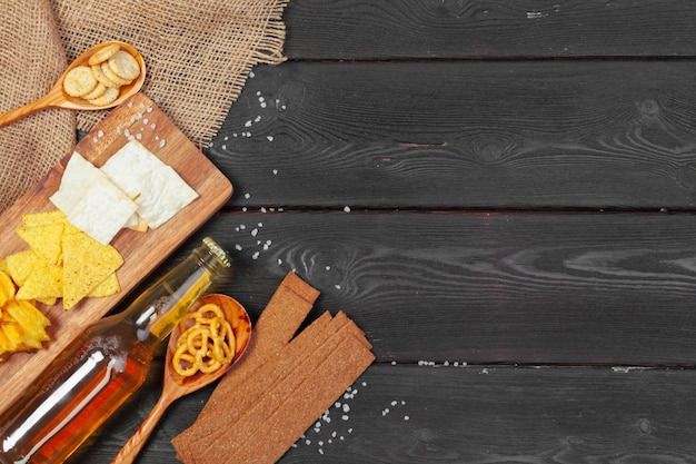 Lager beer and snacks on wooden table.