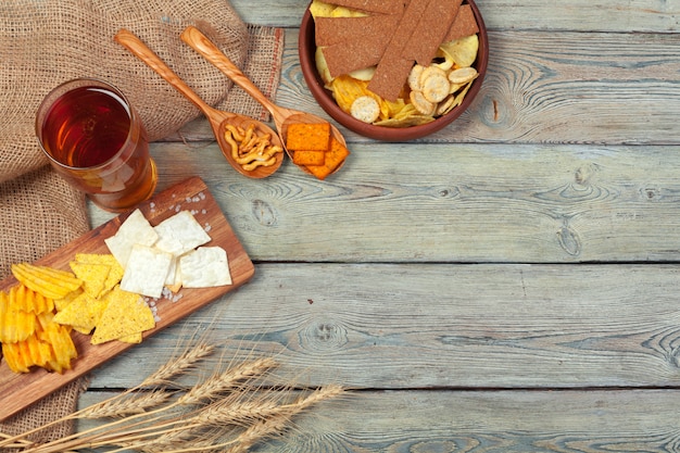 Lager beer and snacks on wooden table.