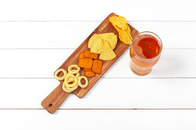 Lager beer and snacks on wooden table.