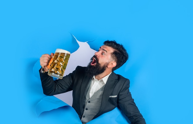 Lager and dark beer bearded man holds craft beer looking through paper hole drinks alcohol leisure