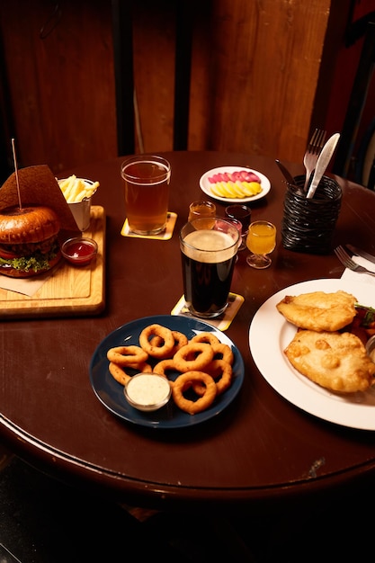 Lager and stout with burger fish and chips golden onion rings and Pickled Marinated eggs on table in pub