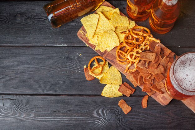 Lagerbierbier en snacks op houten lijst.