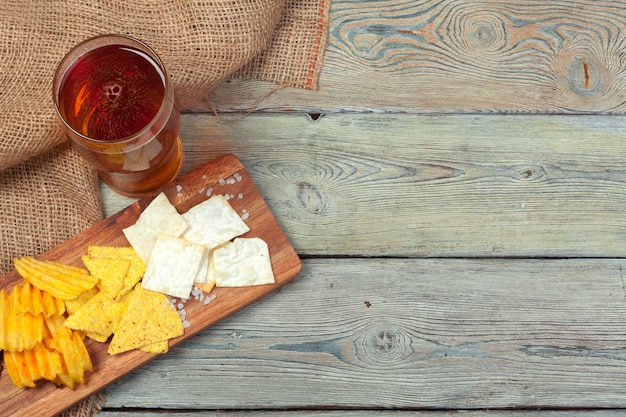 Lagerbierbier en snacks op houten lijst.