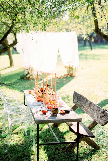 Laid table with candles in a green garden