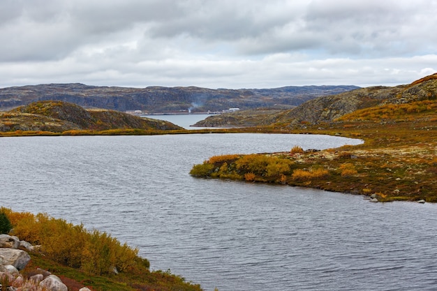 Lake in autumn under a cloudy sky in the tundra. Kola Peninsula, Russia.