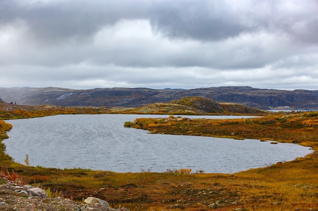 Lake in autumn under a cloudy sky in the tundra. Kola Peninsula, Russia.