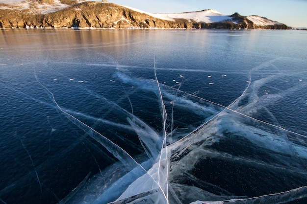 Lake Baikal is covered with ice and snow, strong cold, thick clear blue ice