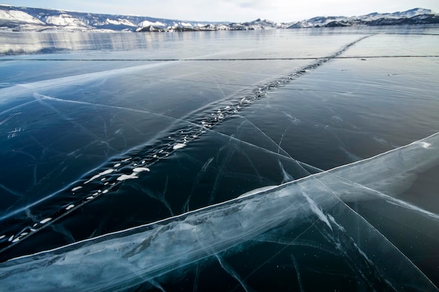 Lake Baikal is a frosty winter day. Largest fresh water lake. Lake Baikal is covered with ice and snow, strong cold and frost, thick clear blue ice. Icicles hang from the rocks. Amazing place heritage