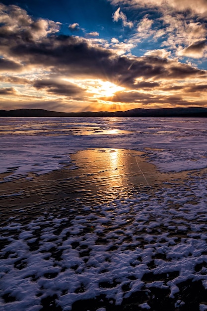 Lake bedekt met ijs tegen de achtergrond van zonsondergang