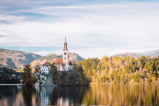 Lake Bled in the Alpine mountains in autumn under blue sky