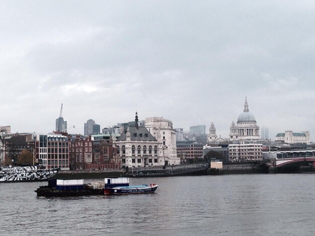 Lake by buildings against sky in city