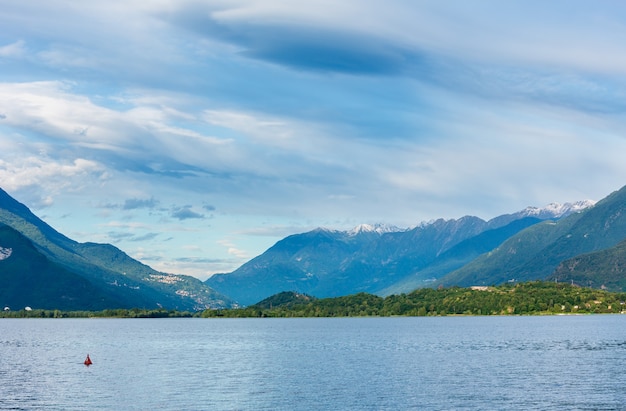 Lake Como (Italy) summer cloudy view with snow on mount top .