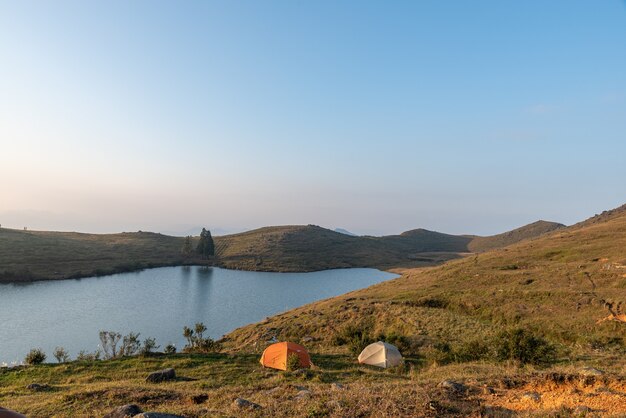 Nel lago sulla prateria, la gente monta le tende in riva al lago;