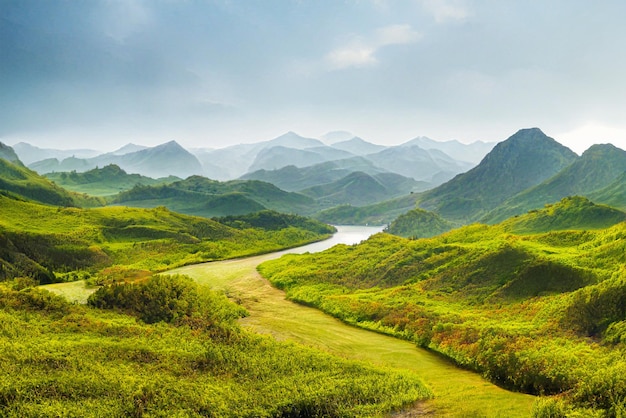 Lake and green mountain with nice sky. A green water lake into the mountains and hills. Green jungle