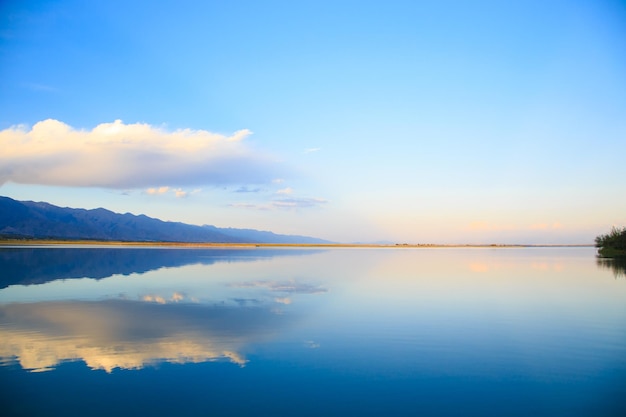 Lake in the mountains Beautiful nature reflection of clouds and mountains in blue water Kyrgyzstan Lake IssykKul