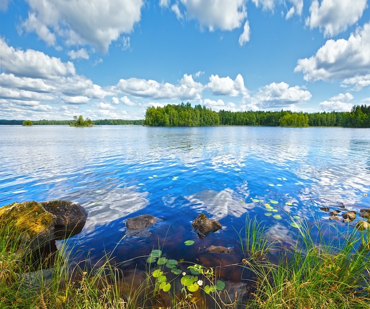 Фотография летний вид на озеро рутаярви с отражением облаков на поверхности воды (урьяла, финляндия).
