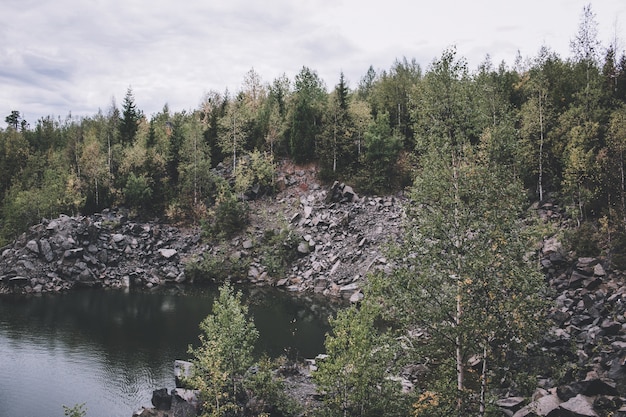 Lake scenes in forest, national park kachkanar, russia, europe. cloudy weather, dramatic blue color sky, far away green trees