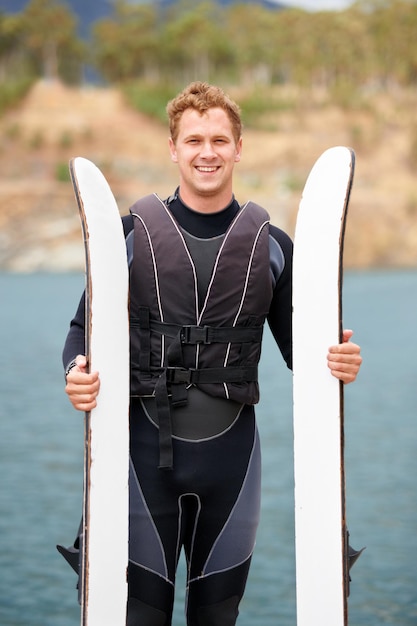 Photo lake ski and portrait of man with wakeboard for surfing exercise and recreation hobby outdoors fitness extreme sports and happy person with board for water skiing for freedom adventure and fun