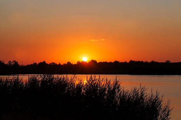 Lake during sunset with yellow-orange sky