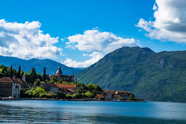 Lake with built structures against lush mountains