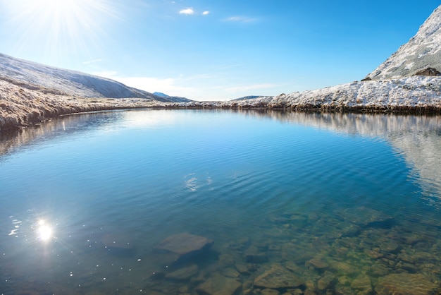 Lake with clear blue water and sunrise sun reflection