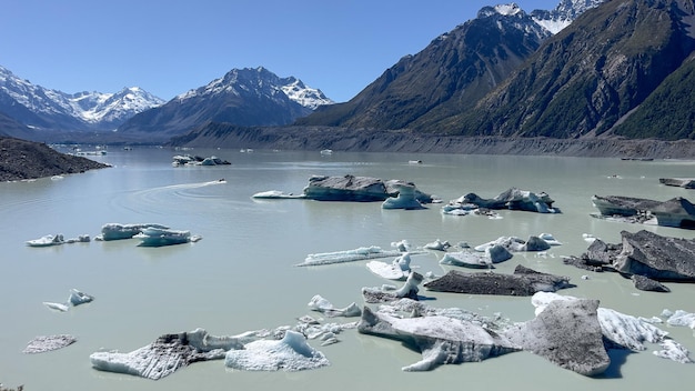 A lake with icebergs and mountains in the background