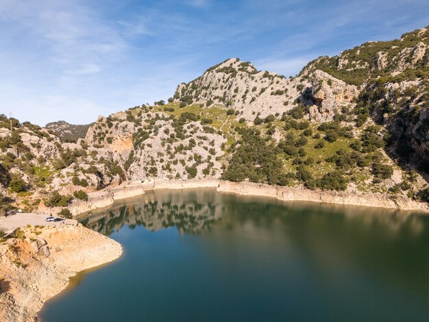 Photo lake with trees and people in the mountains mallorca gorg blau lake